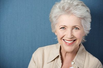 woman smiling after getting all-on-4 dental implants from Clementon Family Dentistry